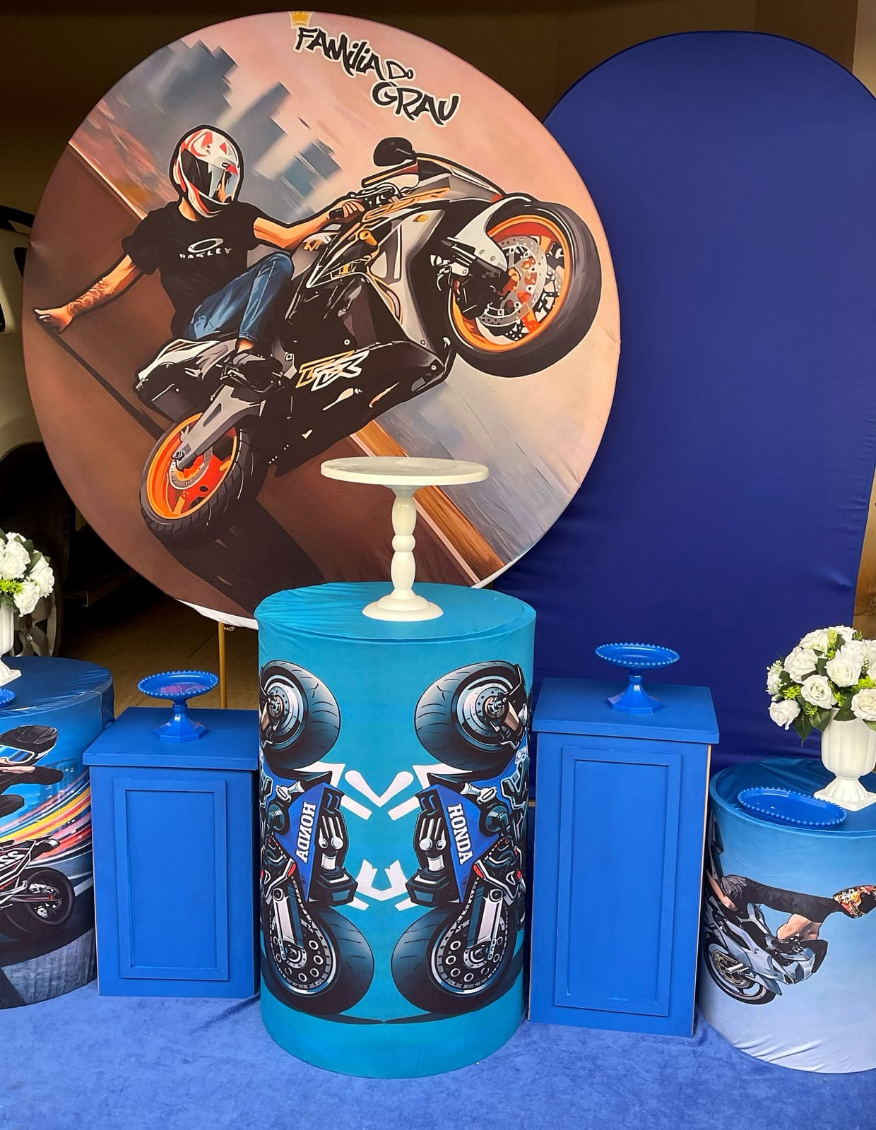Decoração de festa com painel de motociclista e cilindros azuis com estampas de moto