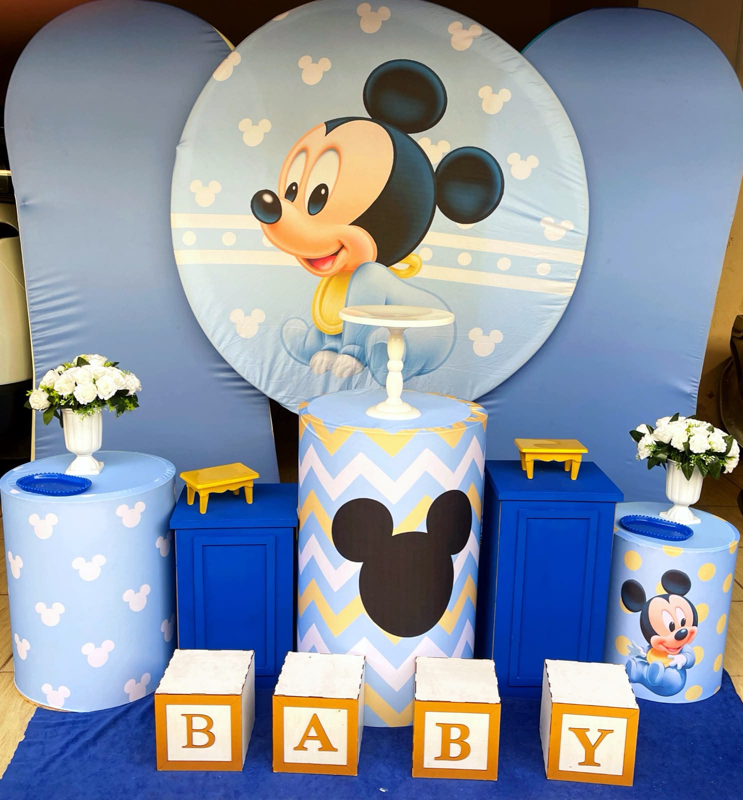 Decoração com painel do Mickey Baby em azul claro, cilindros chevron e cubos BABY