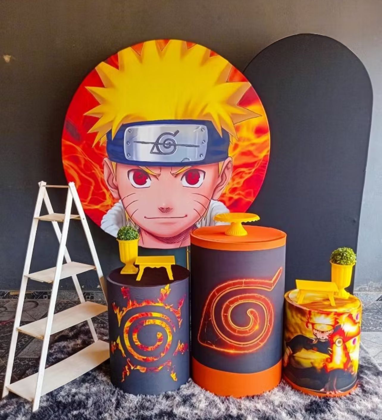Decoração de festa infantil com painel redondo de anime e cilindros laranja e preto